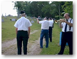 Ken Bradbury plays Taps as the honor guard fires the 21-gun salute