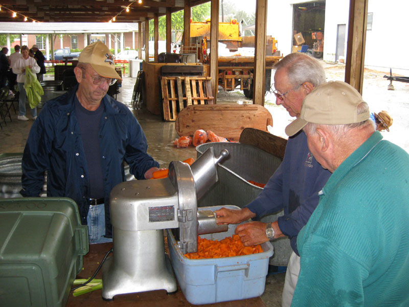 Lorenz Kleinschmidt, Ray Schnitker and Dave Carls operate the vegetable chopper.