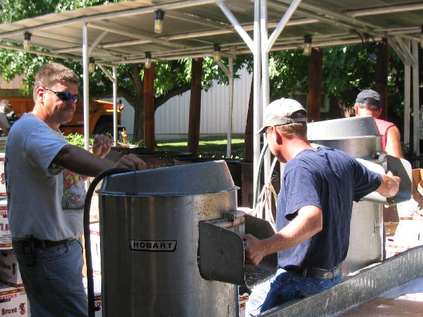 David Huey and Gale Kleinschmidt operate the potato peeling machine.