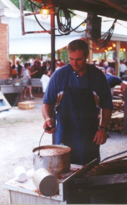 Gerhard Taylor prepares to carry a bucket of steaming burgoo to the serving line