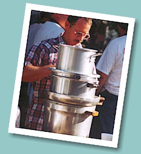 Brian Waibel prepares to fill containers with hot soup from the kettle service.