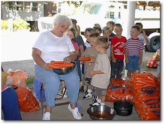 Sara Schone explaining to the pre-school students about her job of peeling carrots.